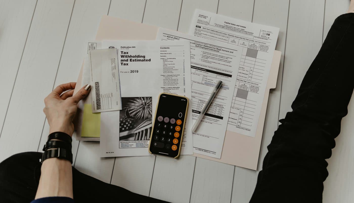 State sales tax forms, a pen and a calculator laid out on a table